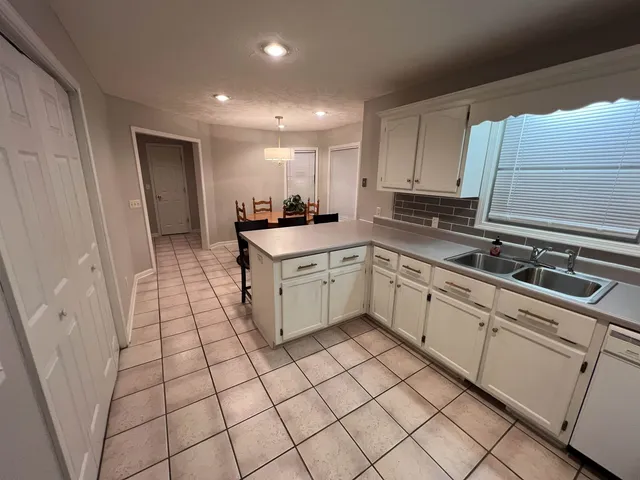 a kitchen with a sink a stove cabinets and a window