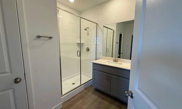 a bathroom with a double vanity sink mirror and shower