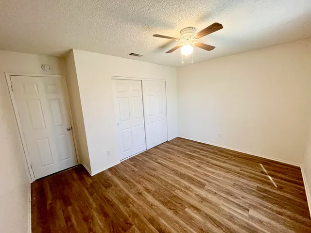 a view of empty room with wooden floor