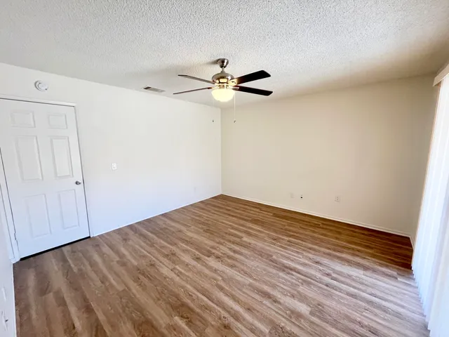 a view of a room with wooden floor and fan