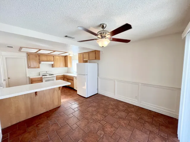 a view of a kitchen with a sink and a refrigerator