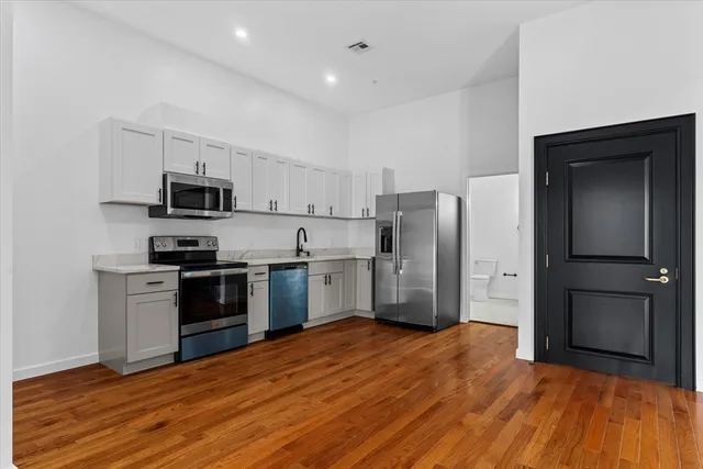 a kitchen with stainless steel appliances a refrigerator and a stove top oven