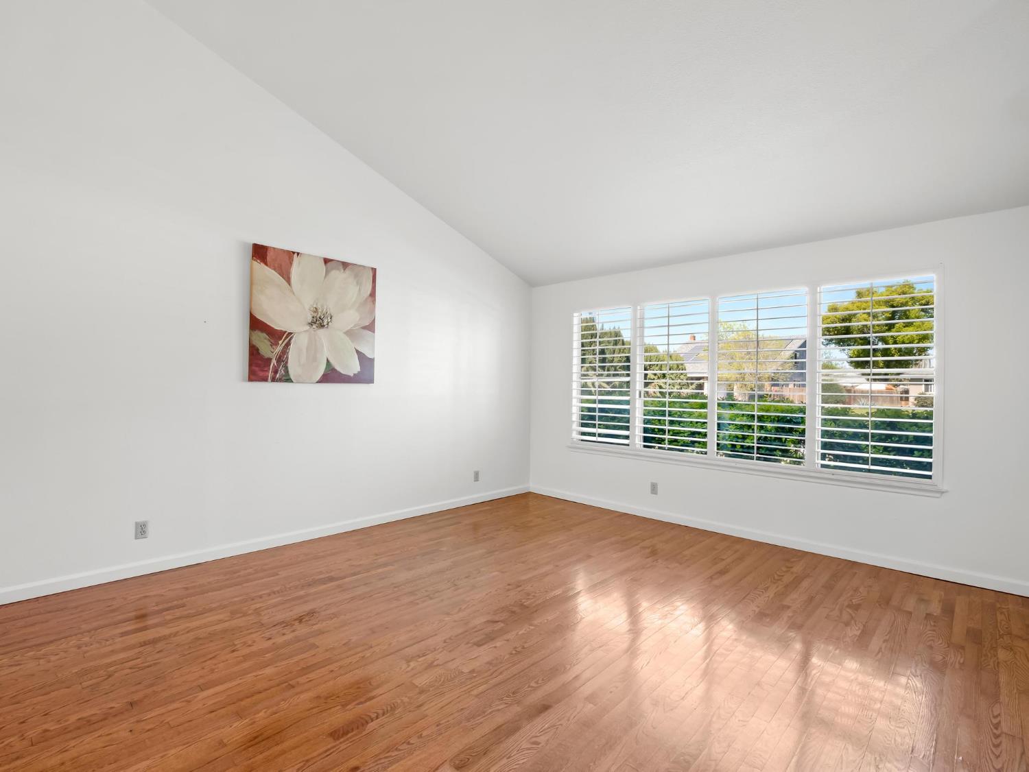 873 Cedar Lane Lemoore, CA 93245 - Photo 12 of 41 a view of an empty room with a window and wooden floor