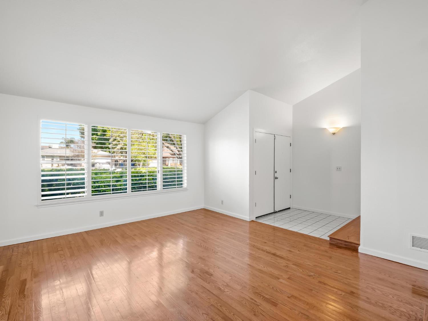 873 Cedar Lane Lemoore, CA 93245 - Photo 13 of 41 a view of an empty room with wooden floor and a window