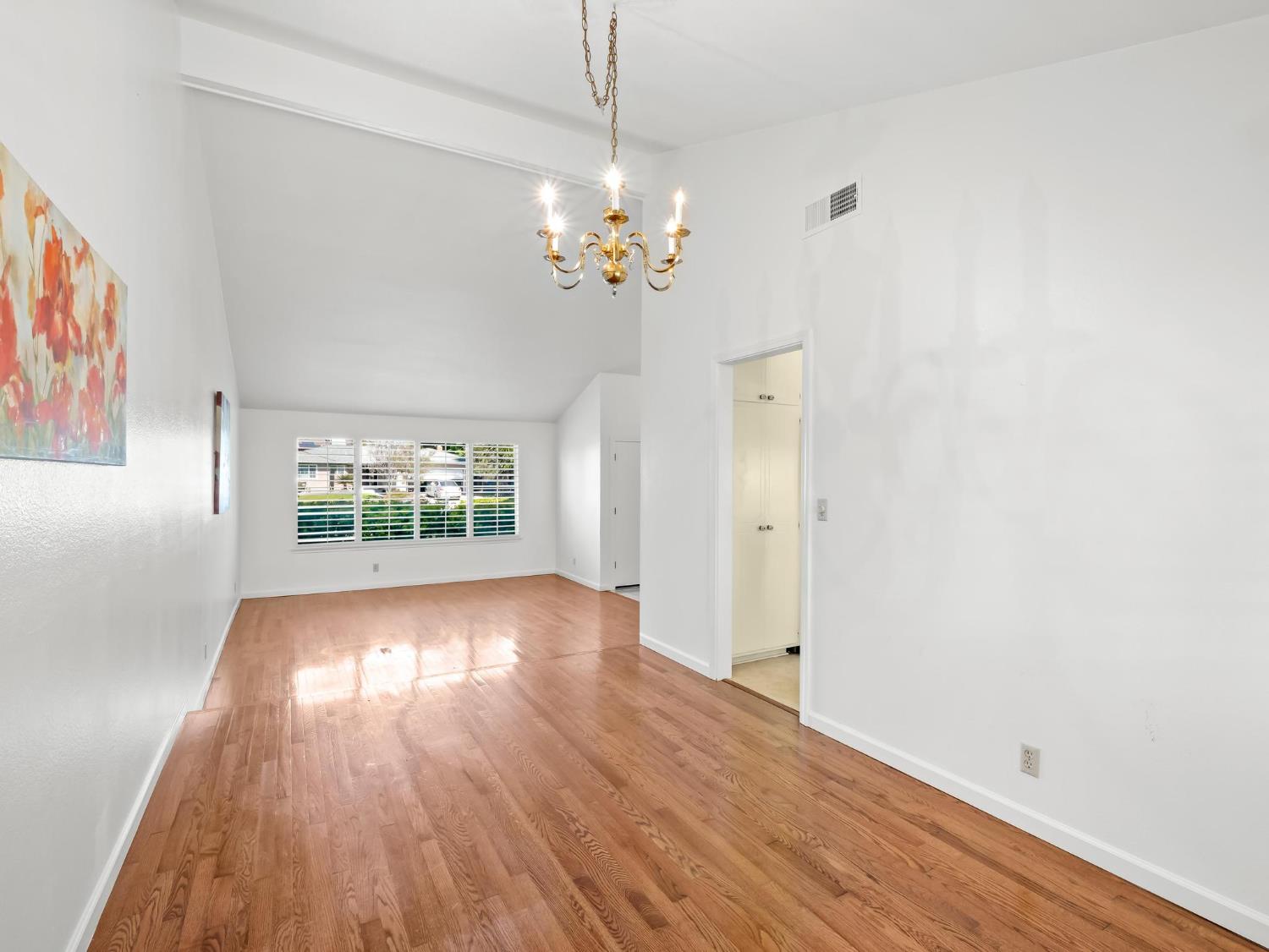 873 Cedar Lane Lemoore, CA 93245 - Photo 15 of 41 a view of an empty room with wooden floor and a window