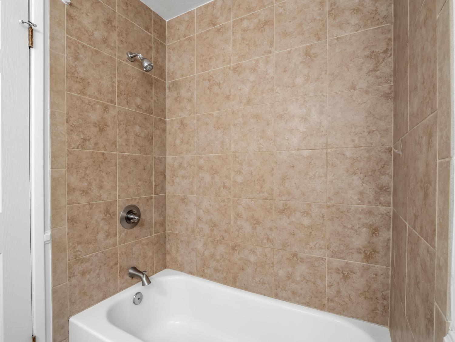 873 Cedar Lane Lemoore, CA 93245 - Photo 39 of 41 a bathroom with a white bath tub and a shower