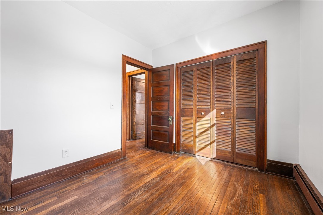 1905 Fulton Road, Unit 2B Cleveland, OH 44113 - Photo 16 of 31 Unfurnished bedroom with dark hardwood / wood-style floors, baseboard heating, and a closet