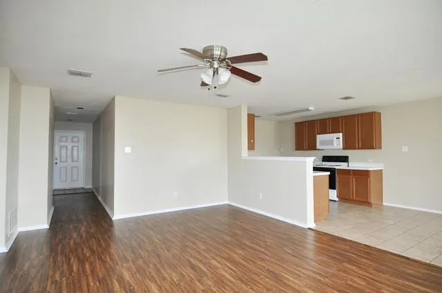 an empty room with a window and a fan