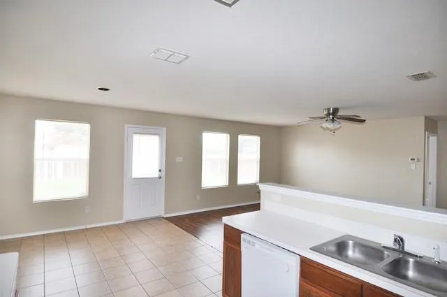 a view of a room with wooden floor and a ceiling fan