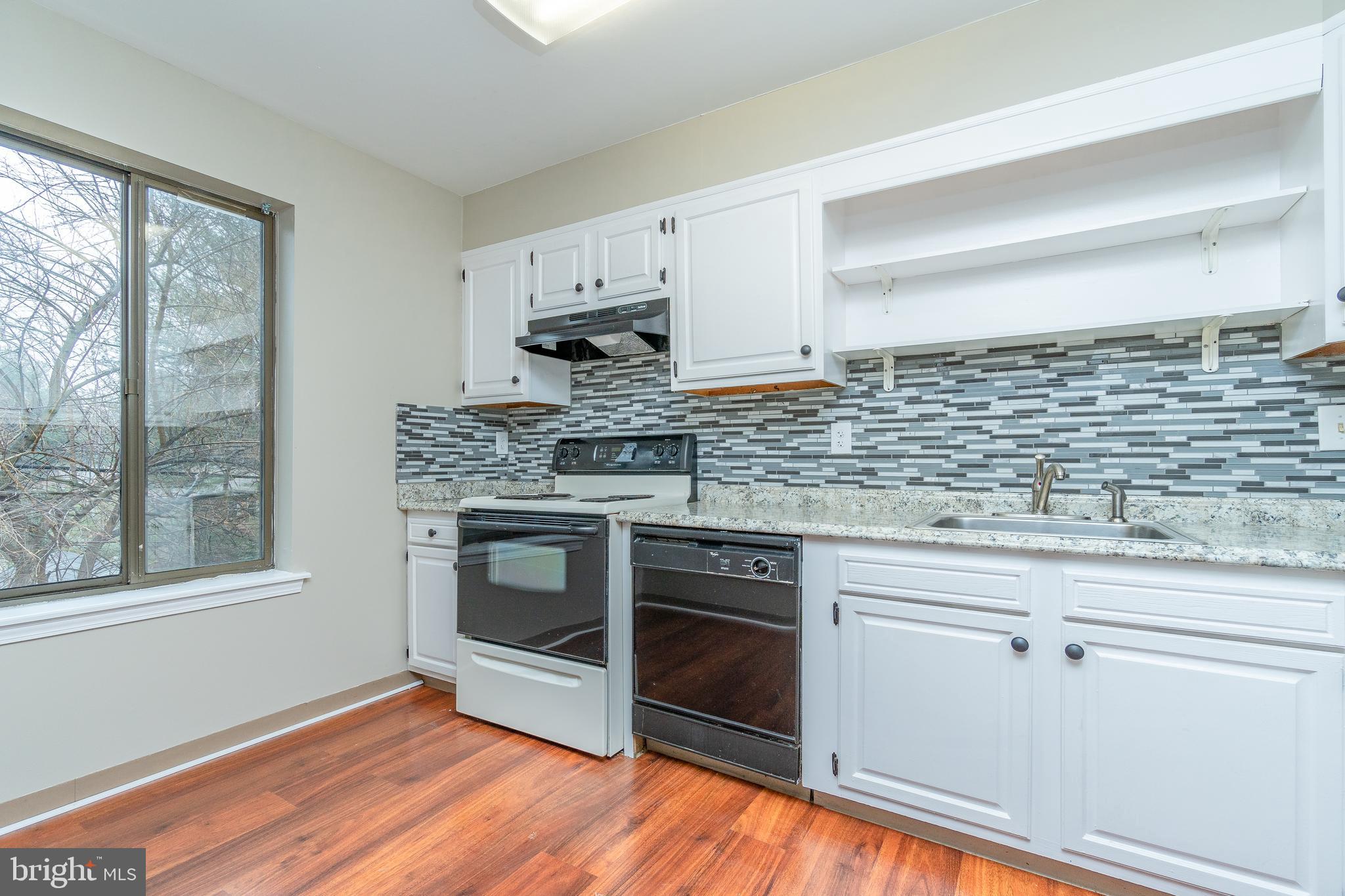 411 Conestoga Road, Unit 22 Devon, PA 19333 - Photo 14 of 27 a kitchen with stainless steel appliances white cabinets and a wooden floor