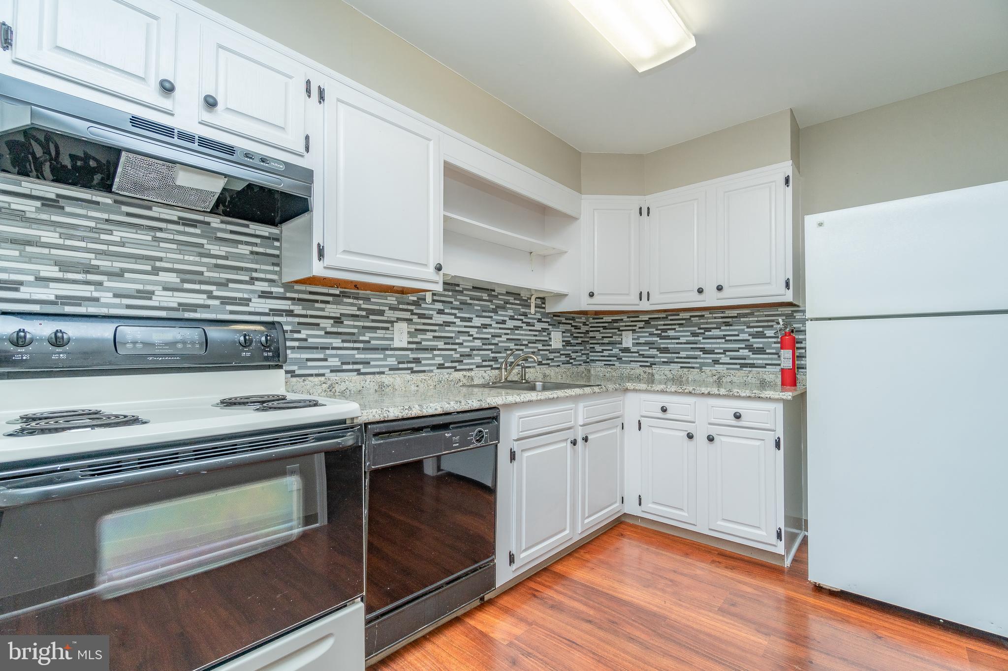 411 Conestoga Road, Unit 22 Devon, PA 19333 - Photo 15 of 27 a kitchen with granite countertop white cabinets and white appliances