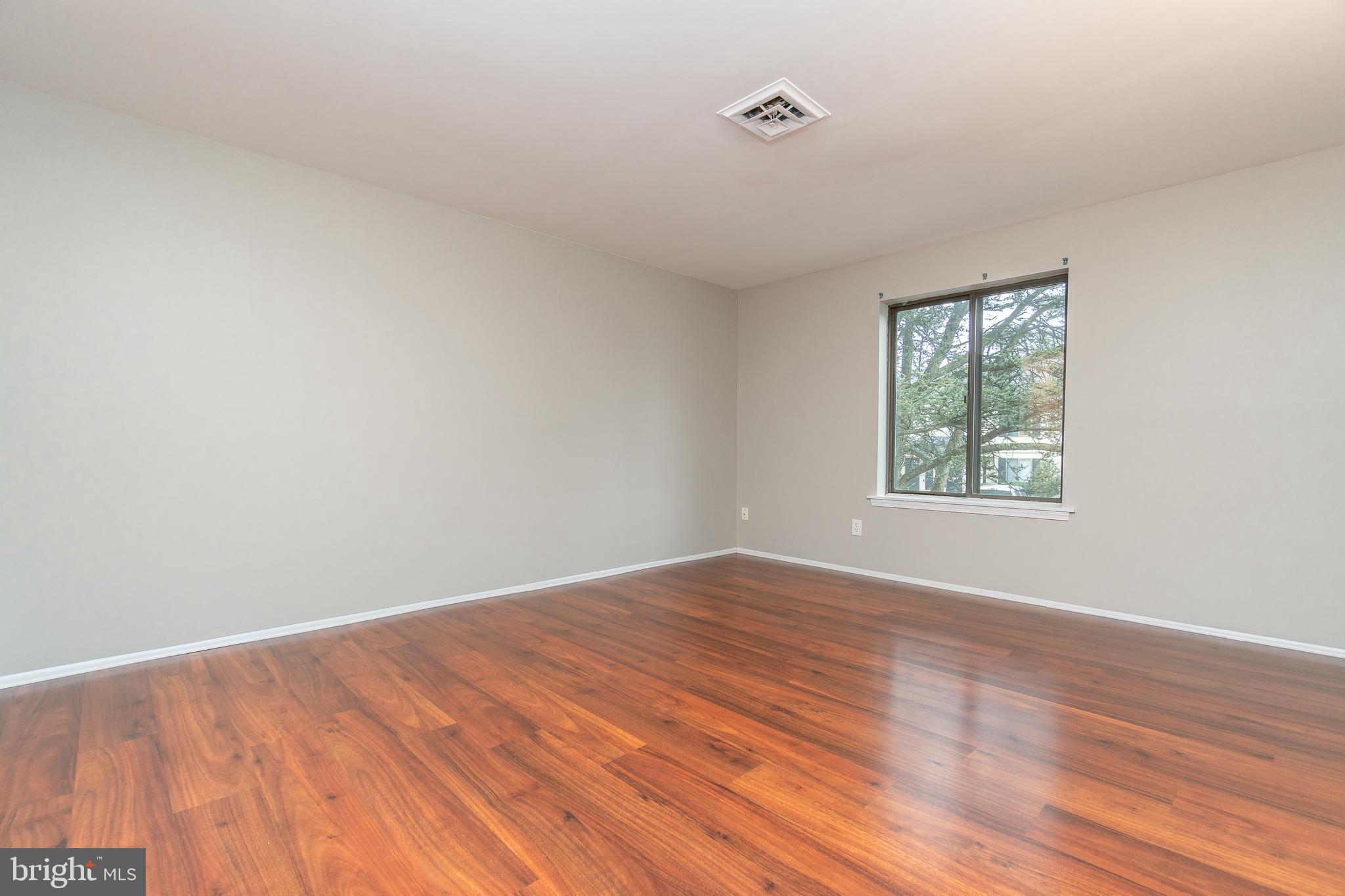 411 Conestoga Road, Unit 22 Devon, PA 19333 - Photo 19 of 27 a view of an empty room with wooden floor and a window