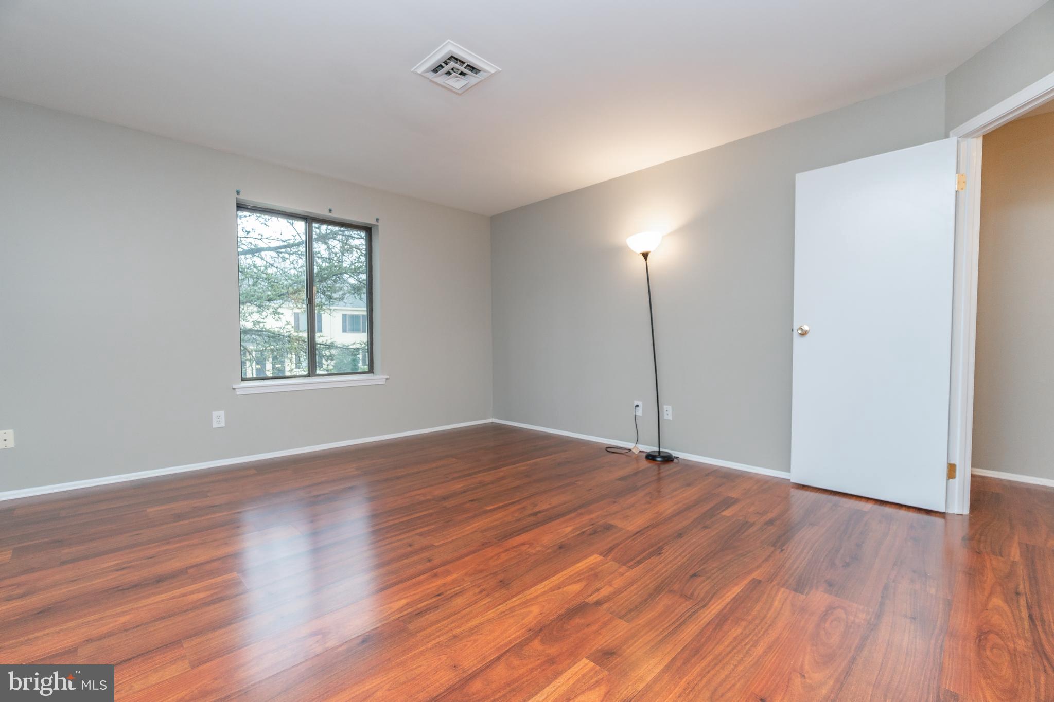 411 Conestoga Road, Unit 22 Devon, PA 19333 - Photo 21 of 27 an empty room with wooden floor and windows