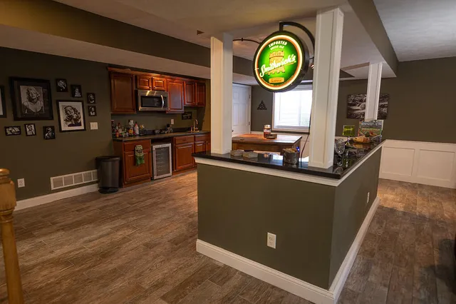 a view of a kitchen with stainless steel appliances granite countertop a stove and a wooden floors