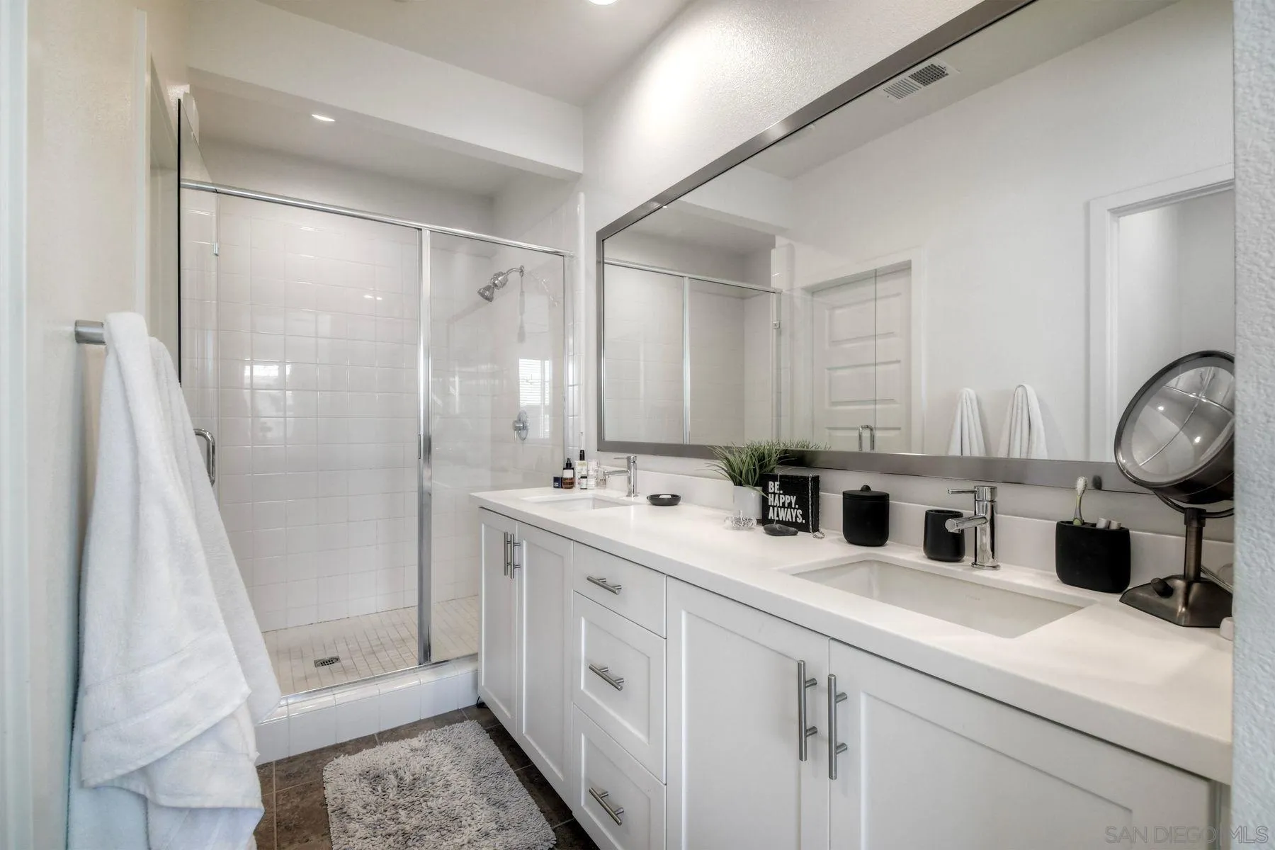 6058 Colt Place, Unit 101 Carlsbad, CA 92009 - Photo 13 of 42 a bathroom with double vanity and a mirror