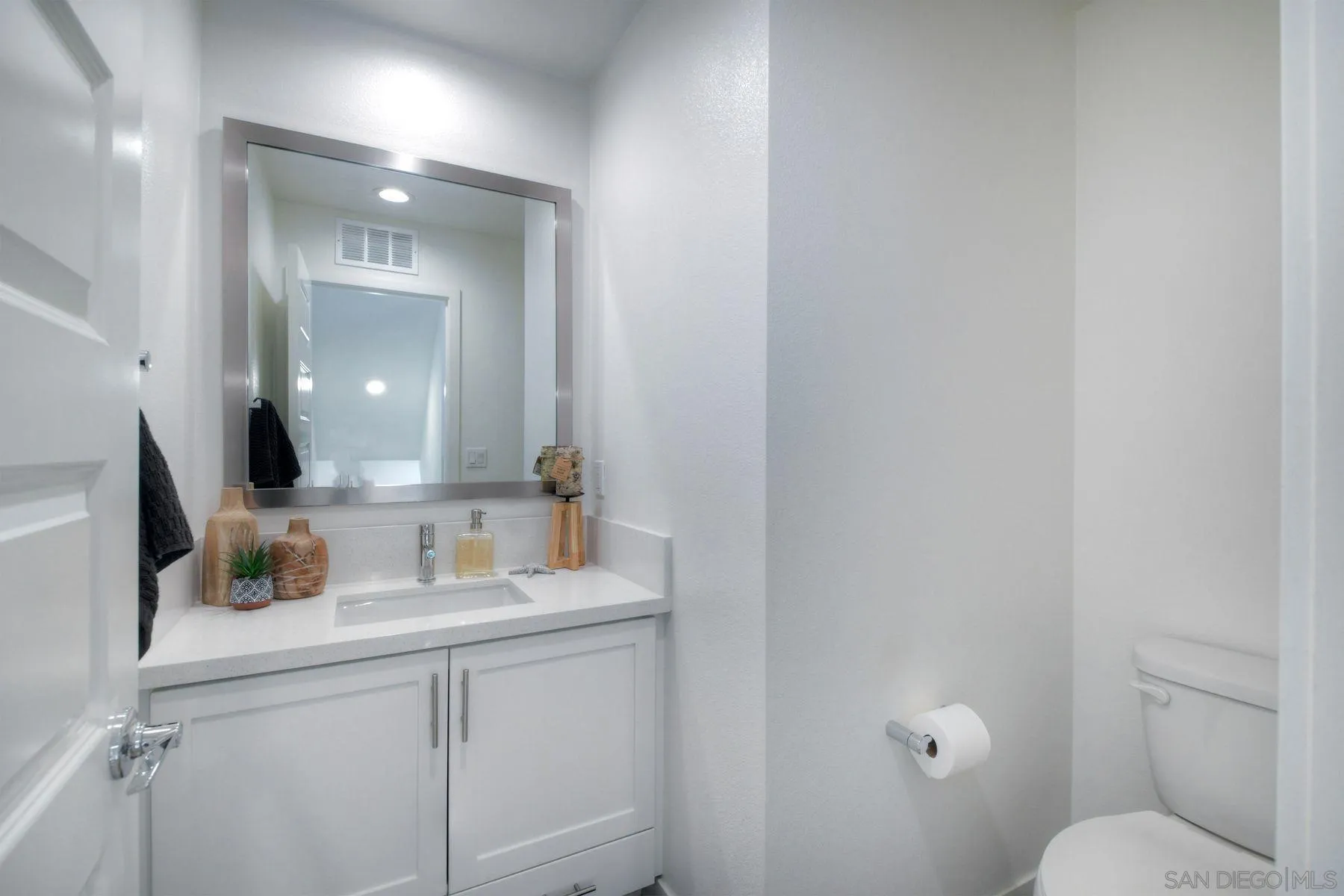 6058 Colt Place, Unit 101 Carlsbad, CA 92009 - Photo 18 of 42 a bathroom with a toilet sink and mirror
