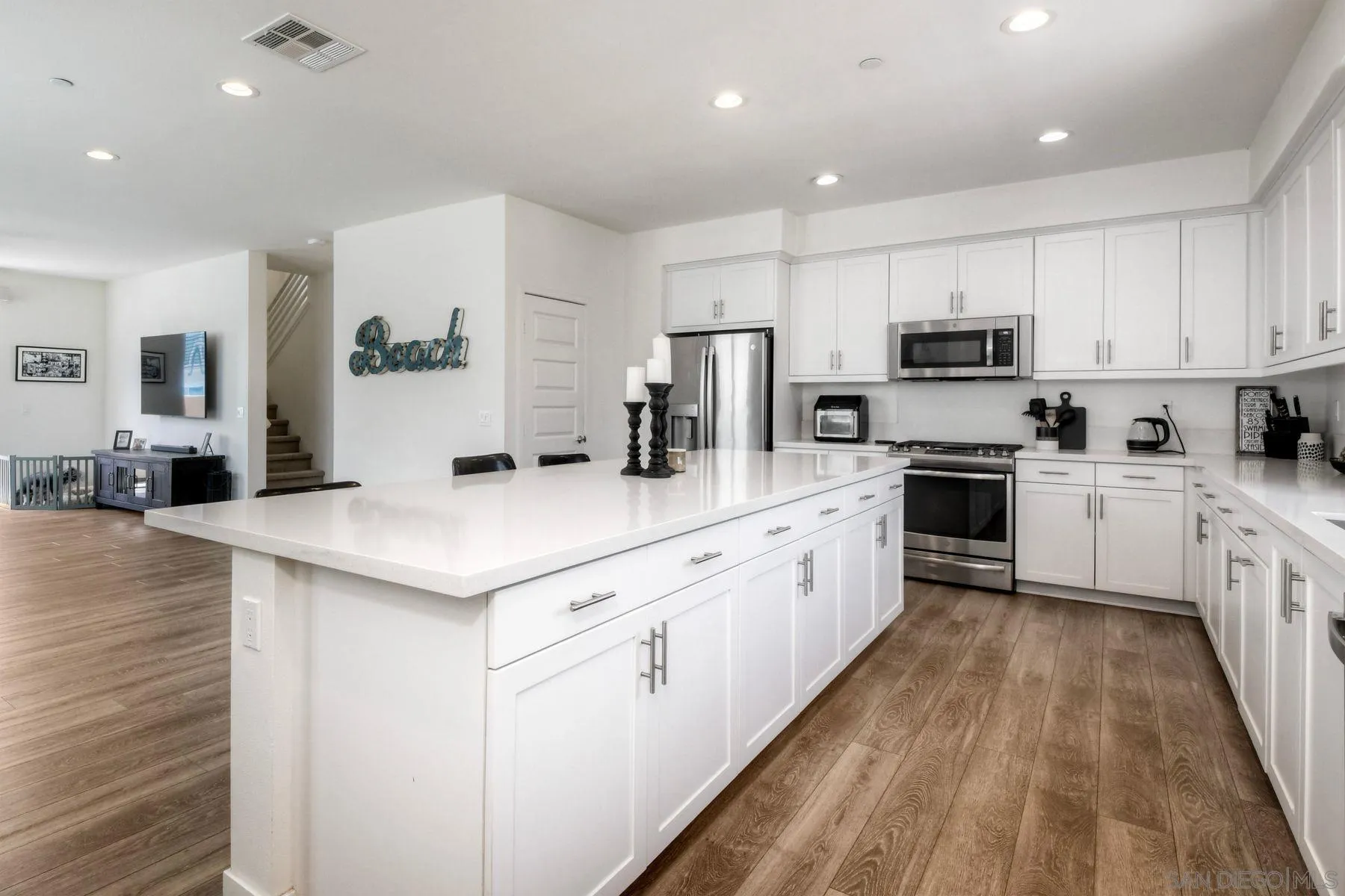 6058 Colt Place, Unit 101 Carlsbad, CA 92009 - Photo 4 of 42 a kitchen with kitchen island a white counter top space stainless steel appliances and cabinets