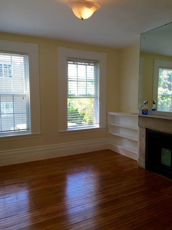 365 Harvard Street Cambridge, MA 02138 - Photo 2 of 15 a view of an empty room with wooden floor and a window