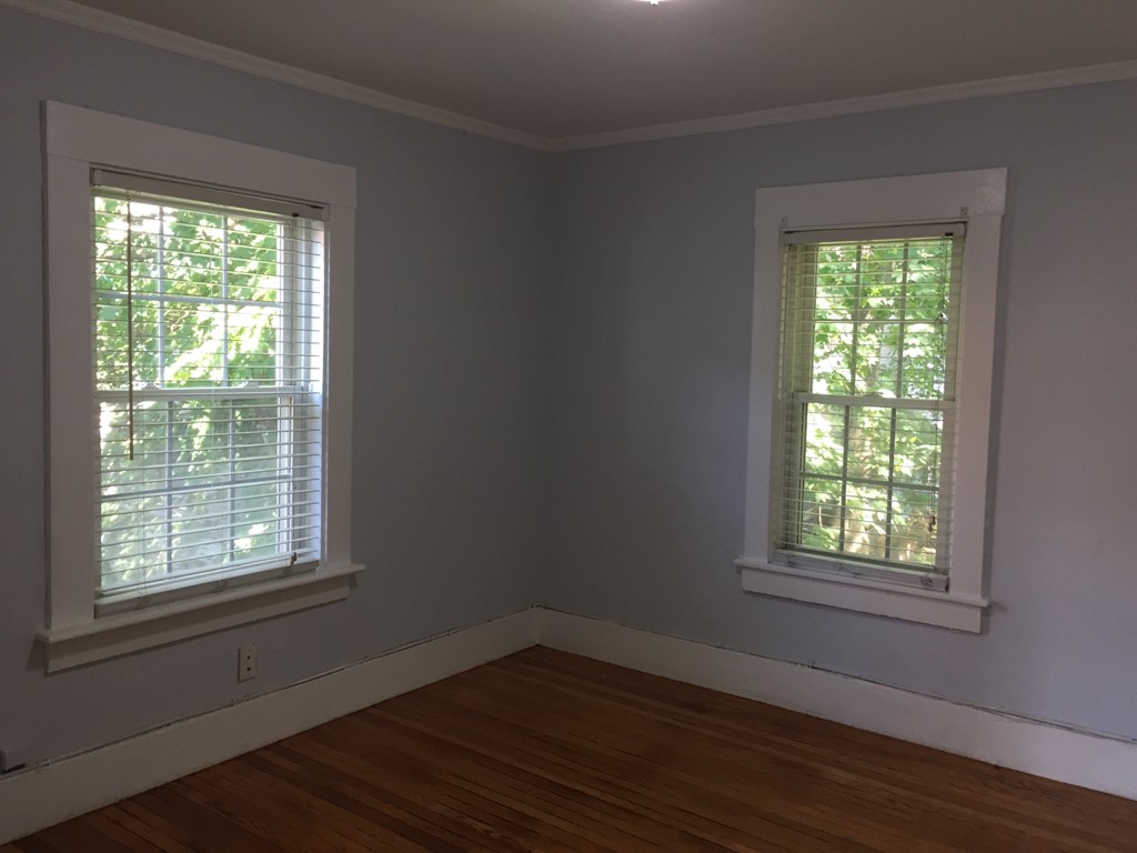 365 Harvard Street Cambridge, MA 02138 - Photo 5 of 15 a view of an empty room with wooden floor and a window