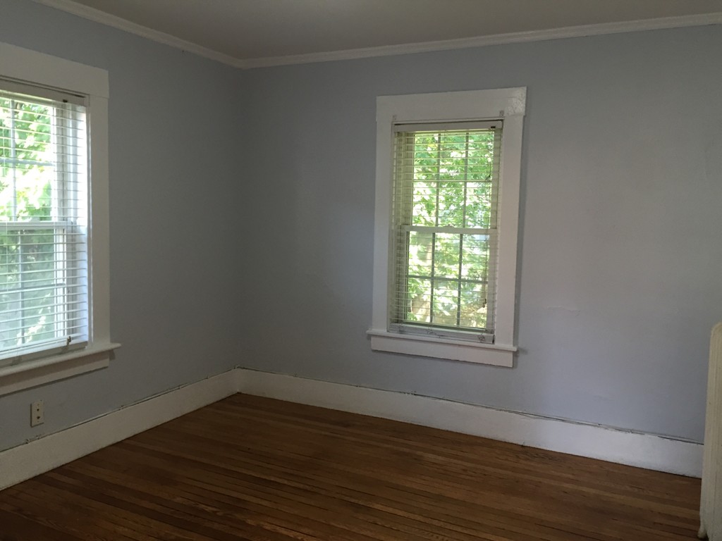 365 Harvard Street Cambridge, MA 02138 - Photo 7 of 15 an empty room with wooden floor and windows