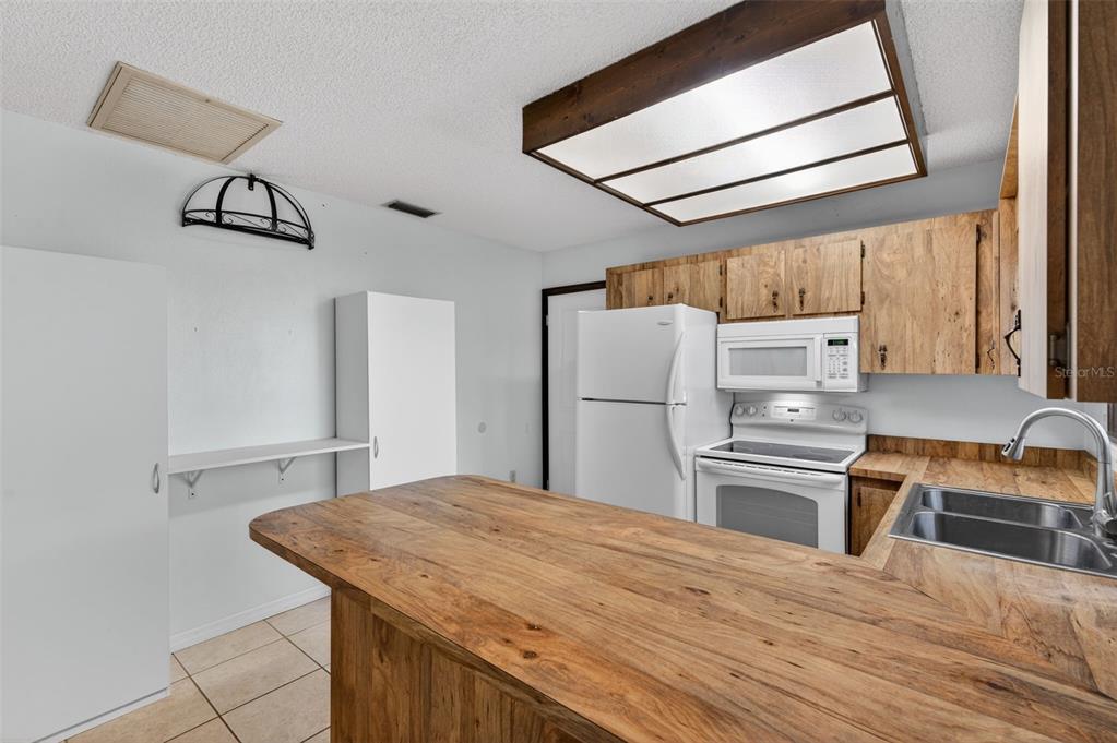 7157 Landmark Drive Spring Hill, FL 34606 - Photo 23 of 57 a kitchen with a refrigerator and a sink