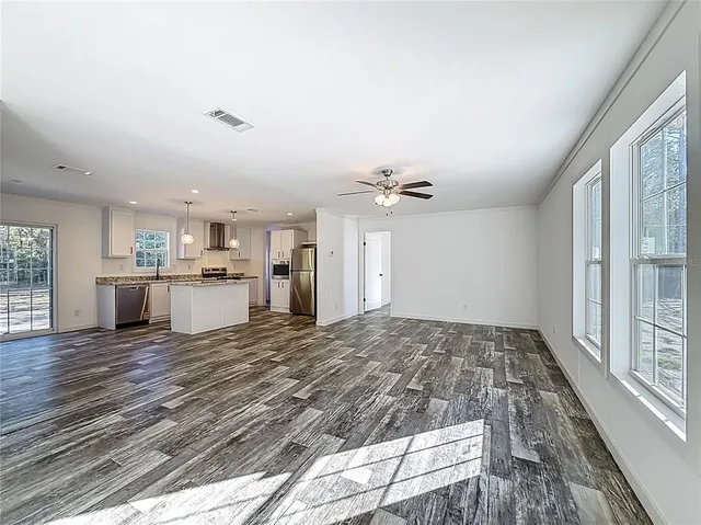 a view of a kitchen with a sink and dishwasher with wooden floor