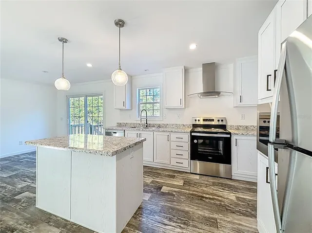 a kitchen with stainless steel appliances granite countertop a sink stove and refrigerator