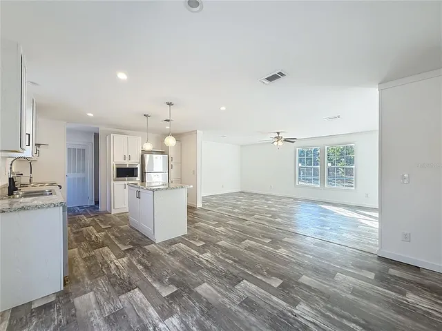 a kitchen with white cabinets and outdoor space