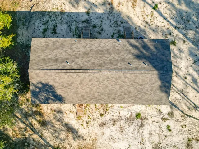 an aerial view of a house with a yard