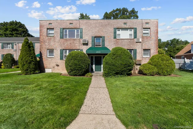front view of a brick house with a yard