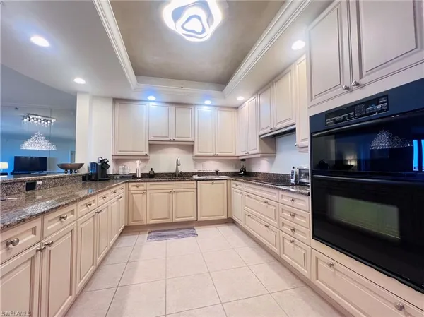 a large kitchen with stainless steel appliances granite countertop a stove a sink and a microwave