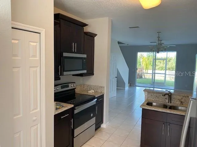 a kitchen with stainless steel appliances granite countertop a stove a sink and a microwave