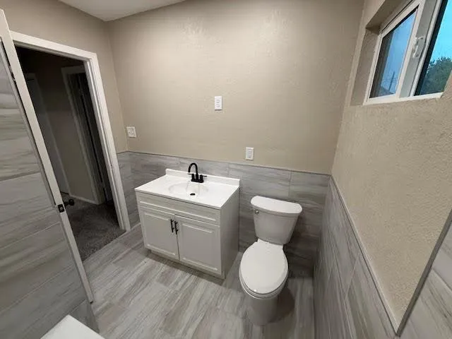 an empty room with a chandelier fan and windows