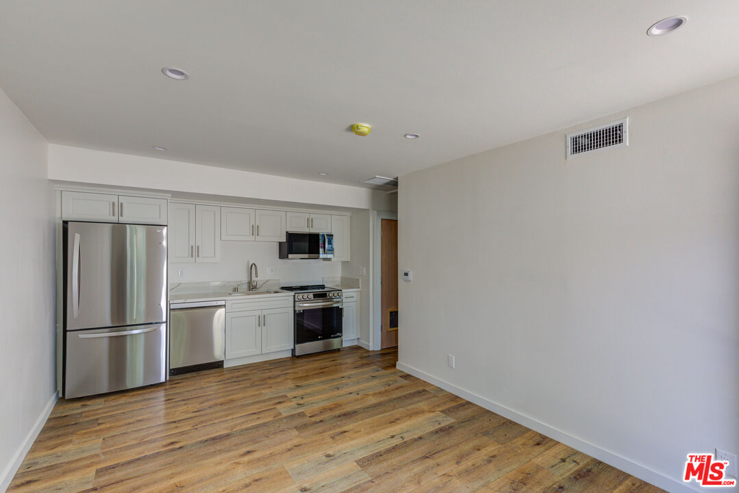 11906 Rochester Avenue Los Angeles, CA 90025 - Photo 3 of 13 a kitchen with a refrigerator and a stove top oven