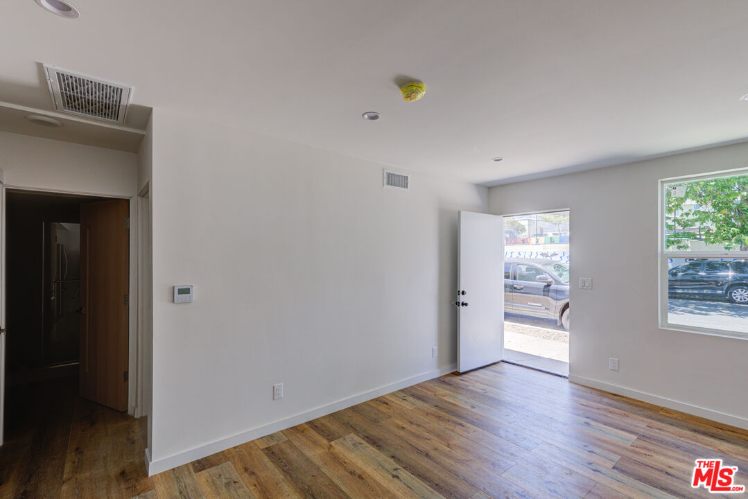 11906 Rochester Avenue Los Angeles, CA 90025 - Photo 6 of 13 a view of an empty room with wooden floor and a window