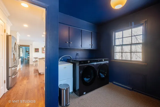 a utility room with stainless steel appliances wooden cabinets and a stove top oven
