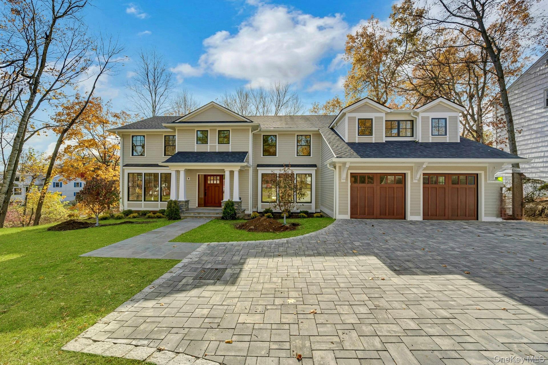 32 Sycamore Road Scarsdale, NY 10583 - Photo 2 of 48 Luxury - move in ready home featuring a decorative stone paver driveway, a front yard, a shingled roof, and a two car garage