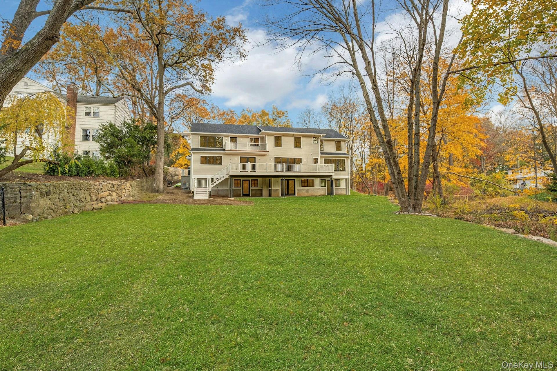 32 Sycamore Road Scarsdale, NY 10583 - Photo 46 of 48 Rear view of house with stairway, a lawn, and a balcony