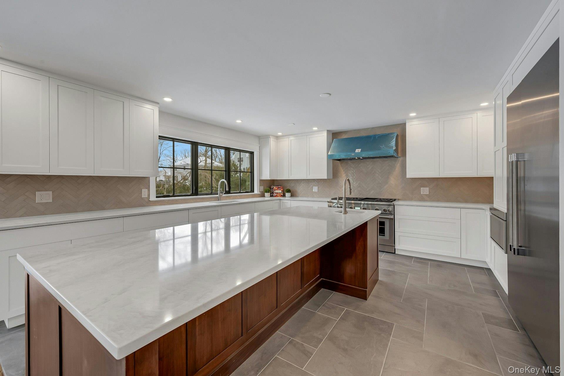 32 Sycamore Road Scarsdale, NY 10583 - Photo 8 of 48 Kitchen featuring quartz counters, white cabinets, wine cooler, a kitchen island, and Thermador stainless appliances