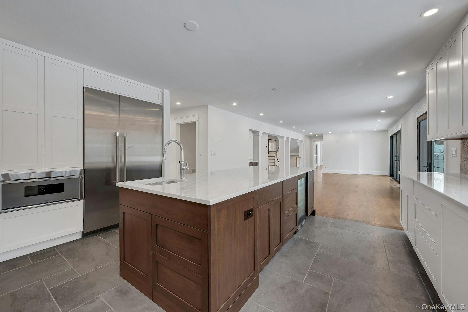 32 Sycamore Road Scarsdale, NY 10583 - Photo 10 of 48 Kitchen featuring quartz counters, white cabinets, wine cooler, a kitchen island, and Thermador stainless appliances