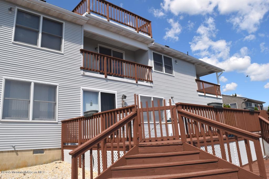 40 Compass Road Waretown, NJ 08758 - Photo 30 of 38 a view of a house with wooden deck stairs and wooden fence