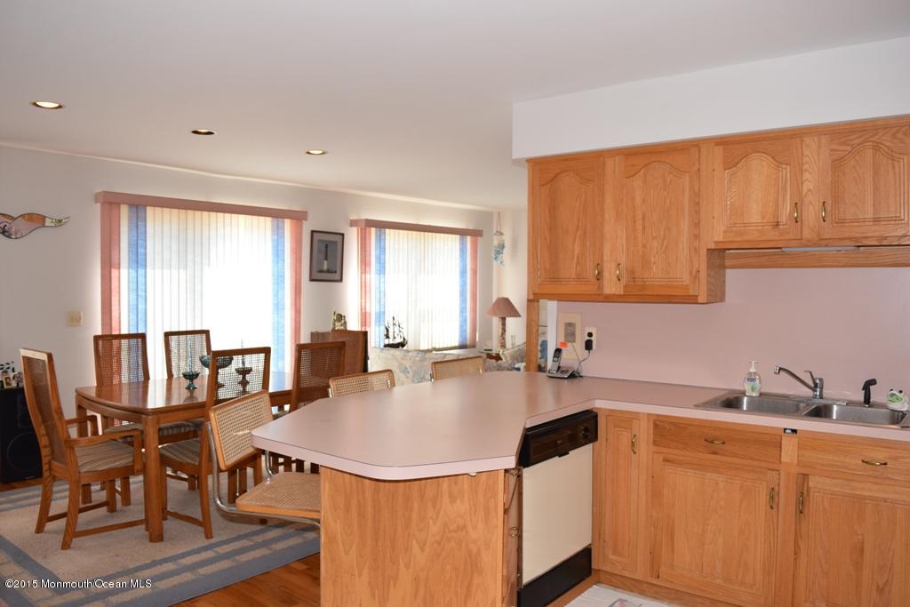 40 Compass Road Waretown, NJ 08758 - Photo 5 of 38 a kitchen with a dining table chairs and white appliances