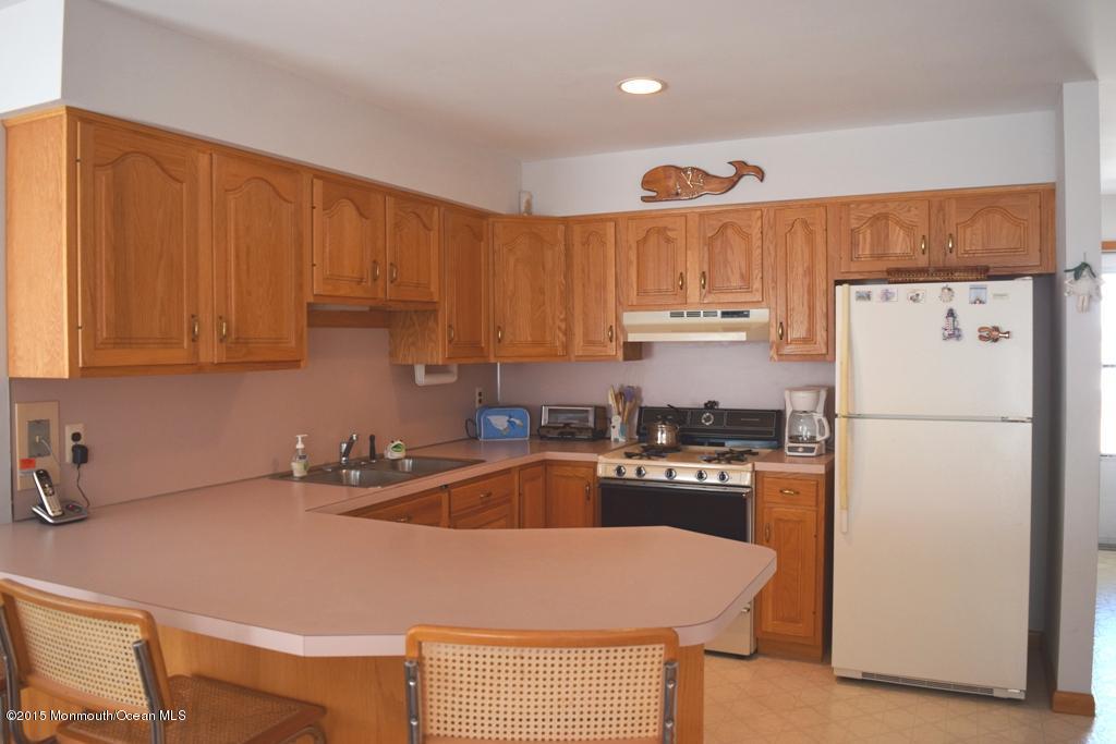40 Compass Road Waretown, NJ 08758 - Photo 7 of 38 a kitchen with stainless steel appliances granite countertop a refrigerator a sink a stove and white cabinets