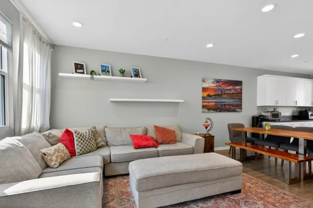 a living room with furniture and a dining table with kitchen view