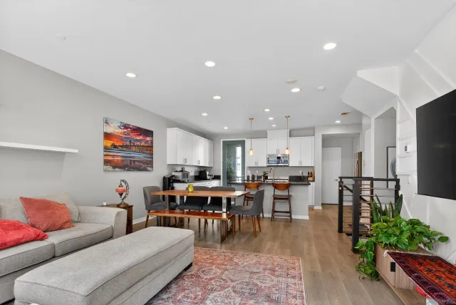 a kitchen with stainless steel appliances kitchen island granite countertop a table chairs and a refrigerator
