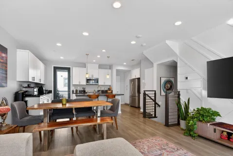 a kitchen with stainless steel appliances a dining table chairs and refrigerator