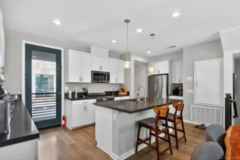 a kitchen with stainless steel appliances granite countertop a sink a stove and a refrigerator