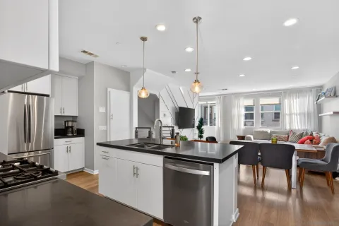a kitchen with stainless steel appliances granite countertop a sink a stove and a wooden floors