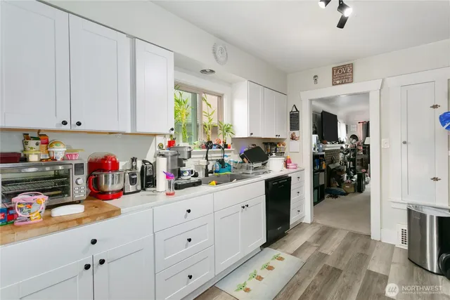 a kitchen filled with white cabinets and appliances