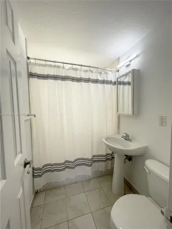 a bathroom with a sink a toilet a mirror and shower